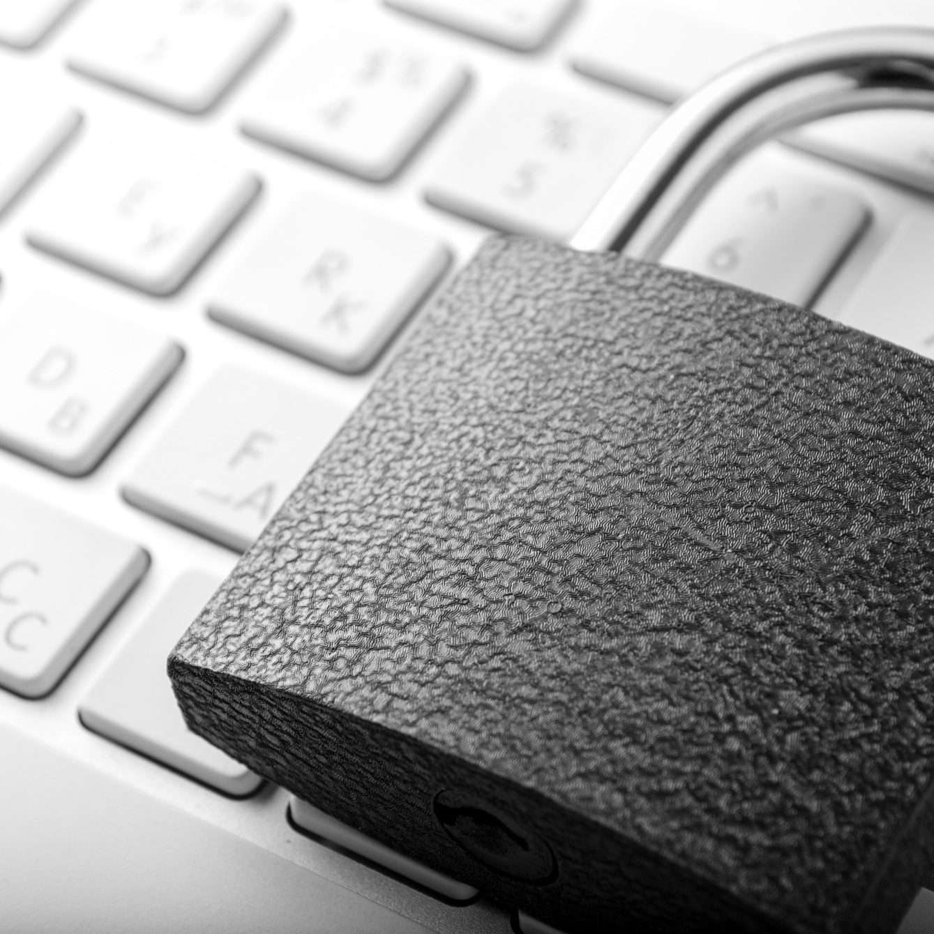 Ein schwarzes Vorhängeschloss liegt auf einer Laptop-Tastatur.